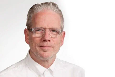 A person wearing glasses and a white shirt
Description automatically generated