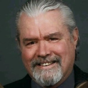A person with white hair and beard Description automatically generated
